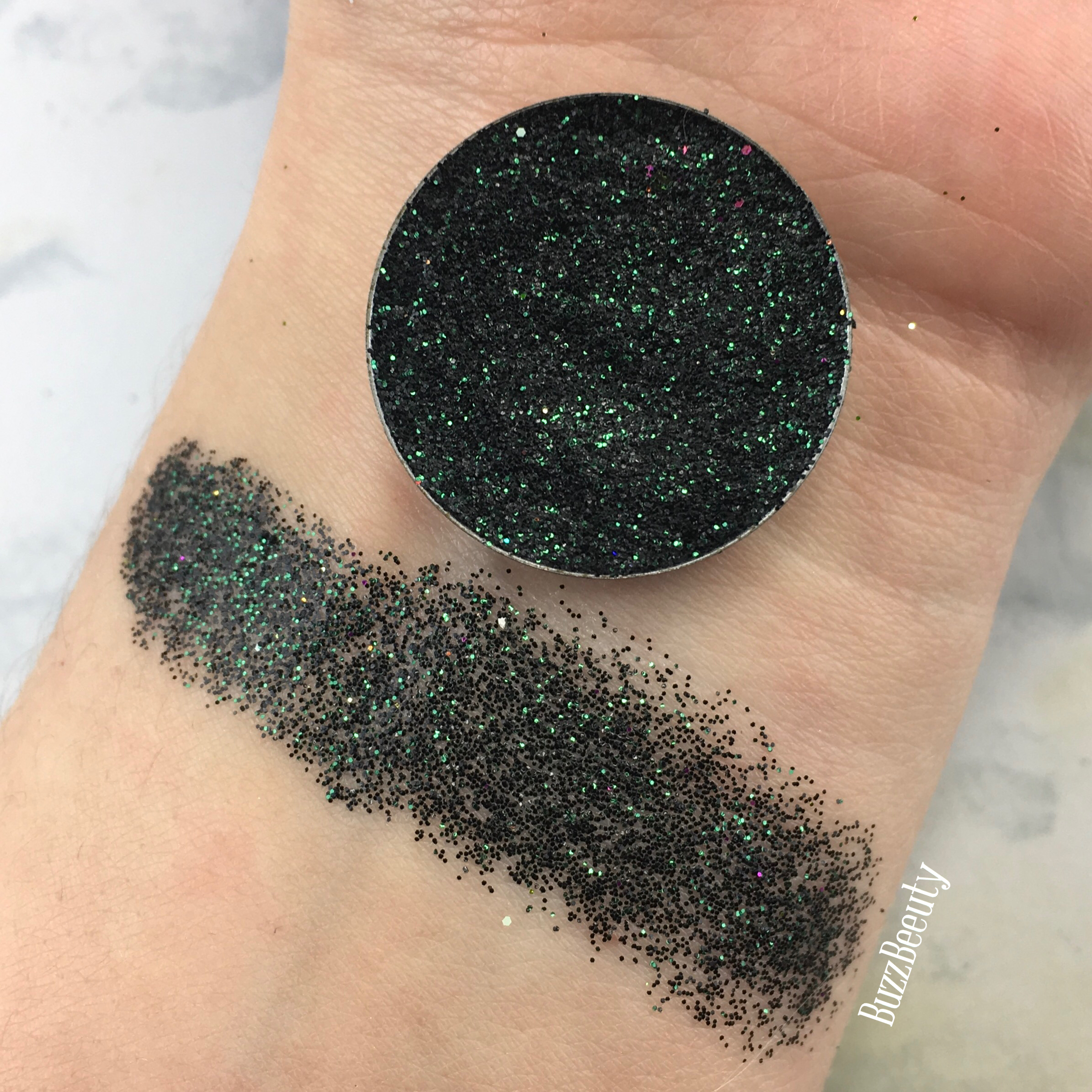 Dear Katie Brown Pressed Glitter Swatch in Smooth Operator. A blackened green base with emerald glitters.