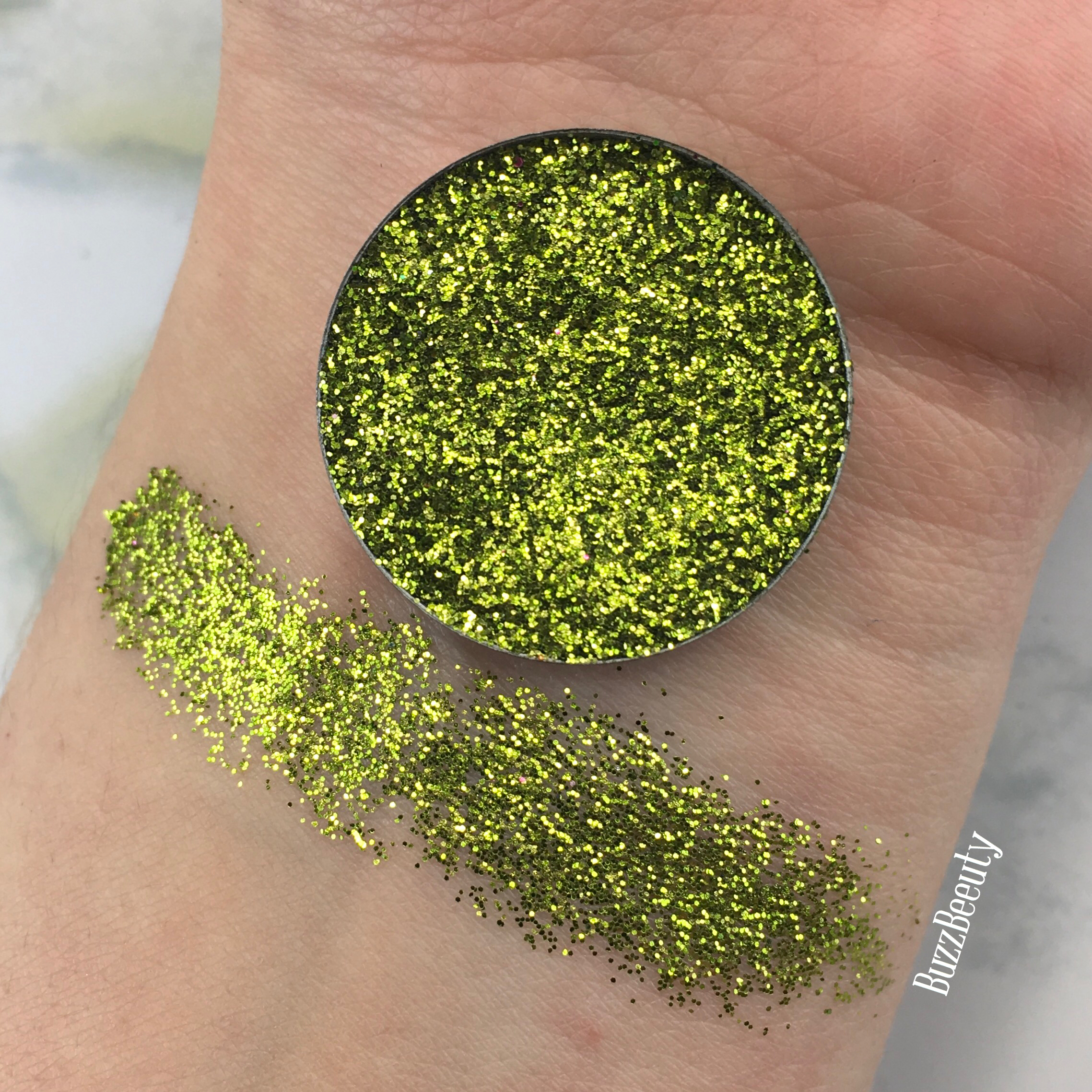 Dear Katie Brown Pressed Glitter swatch in the shade Tejas. Dirty green with gold glitters.